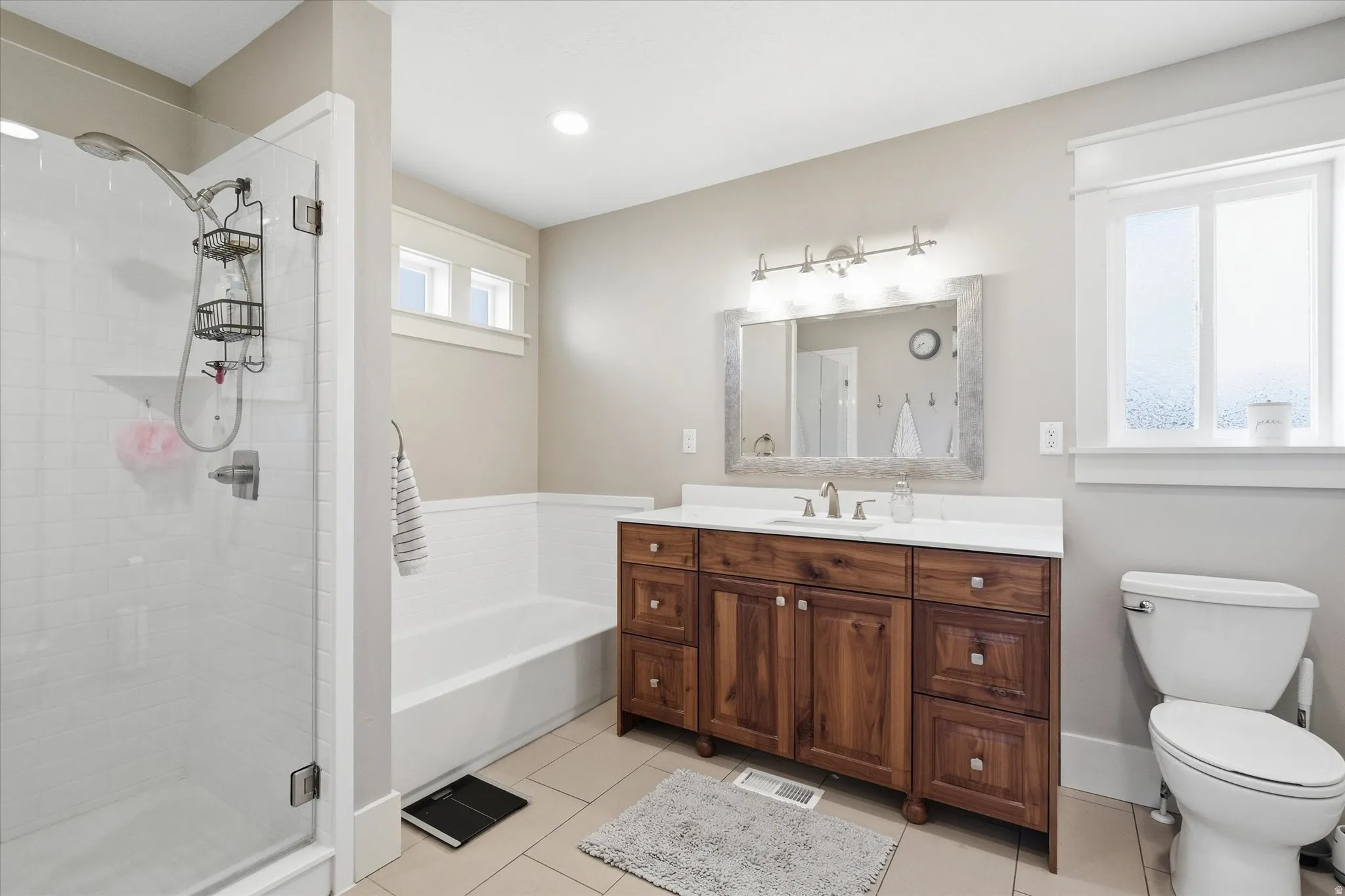 Full bathroom with vanity, light tile patterned floors, a shower stall, and a bath
