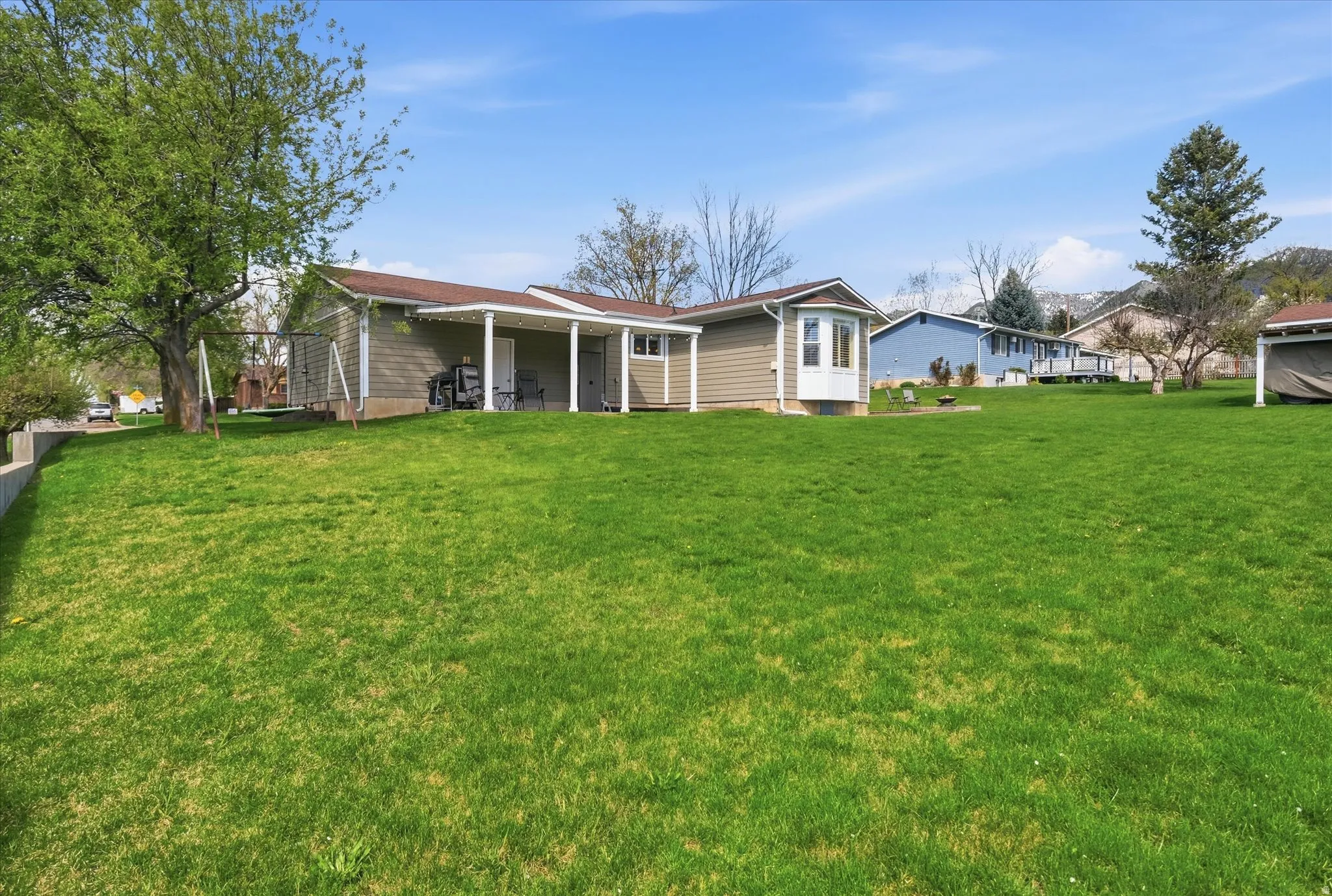 Back of house featuring a lawn and a patio