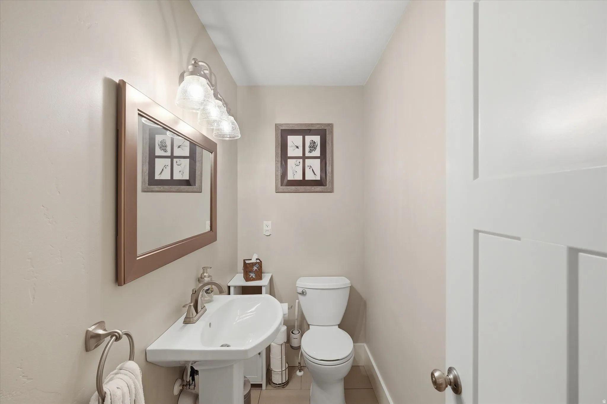 Half bathroom with toilet and tile patterned floors