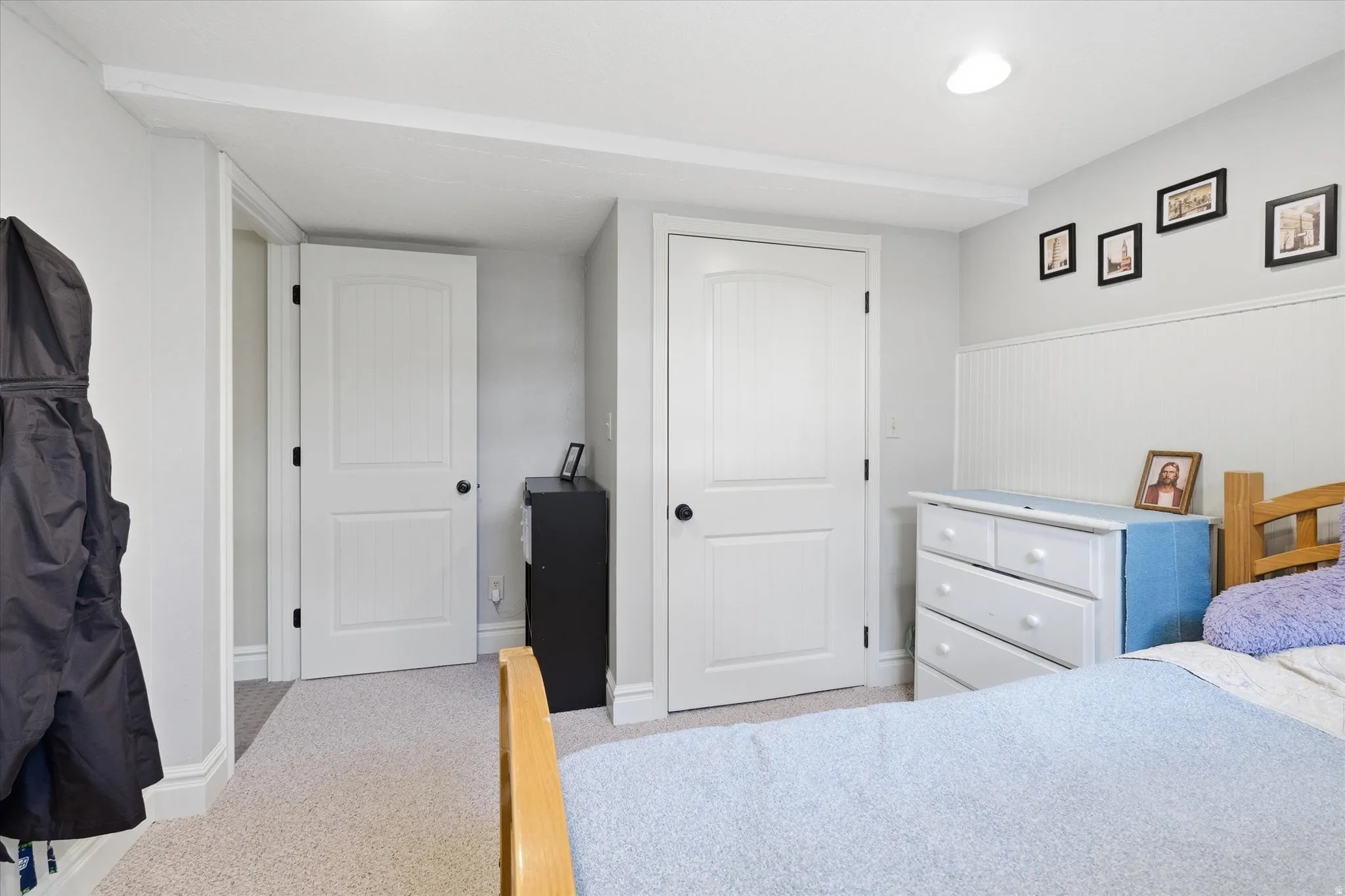 Bedroom with light colored carpet and a closet