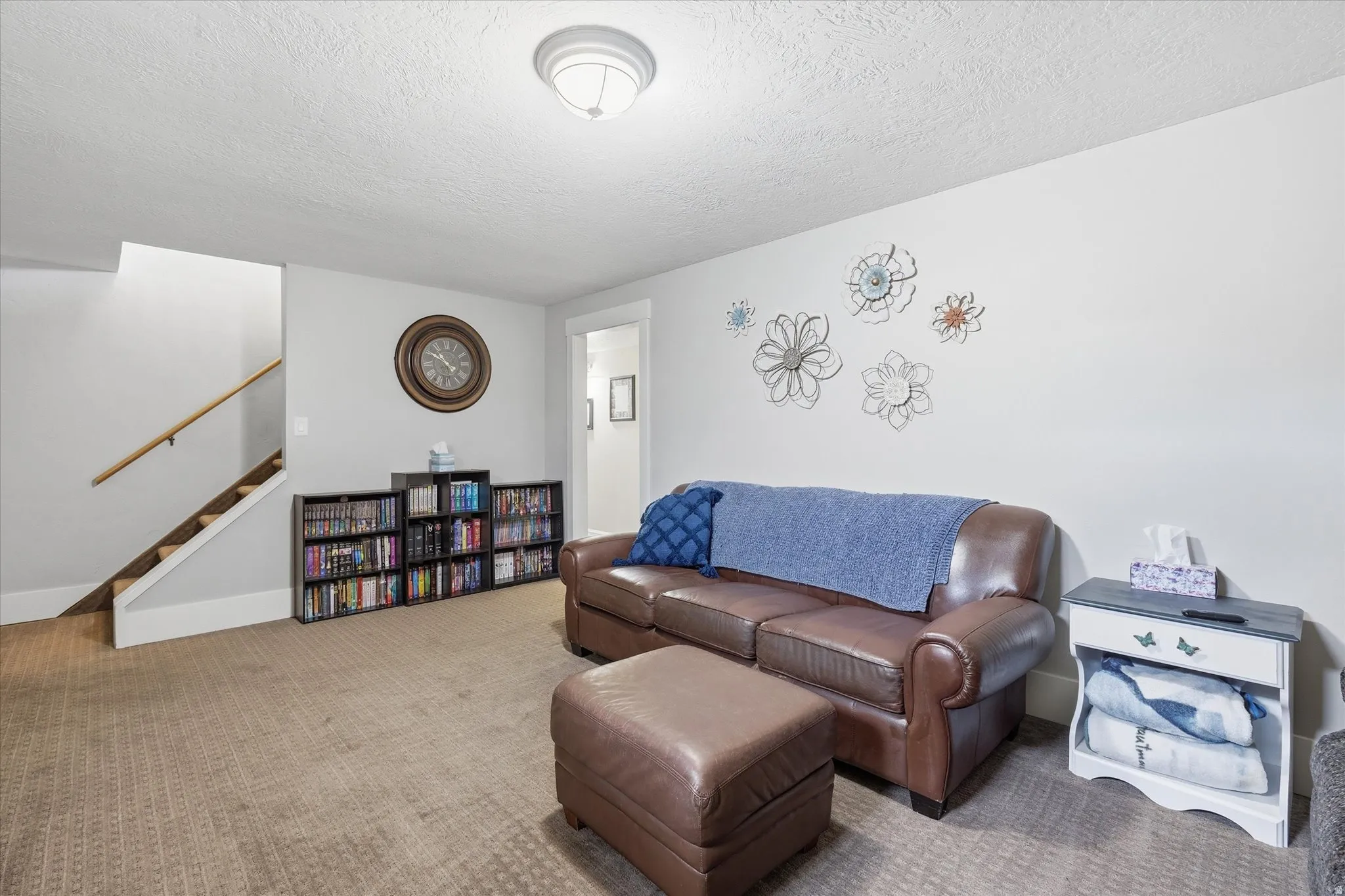 Living area with carpet flooring and a textured ceiling
