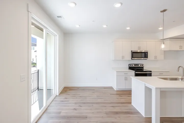 Open-concept kitchen with white cabinetry and light countertops