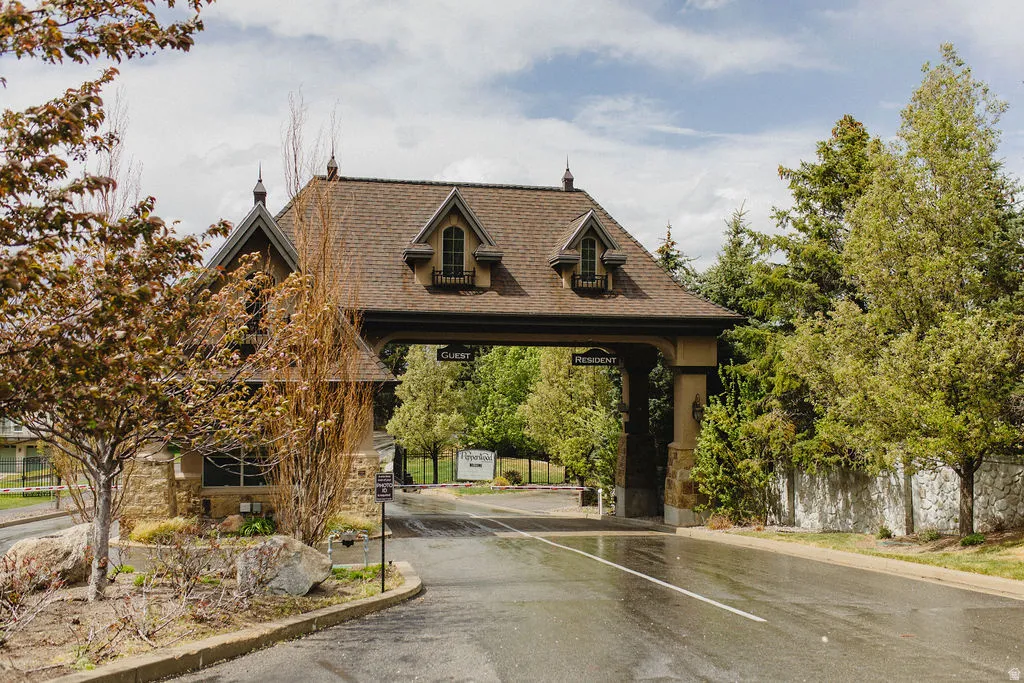 View of asphalt road with curbs and a gated entry