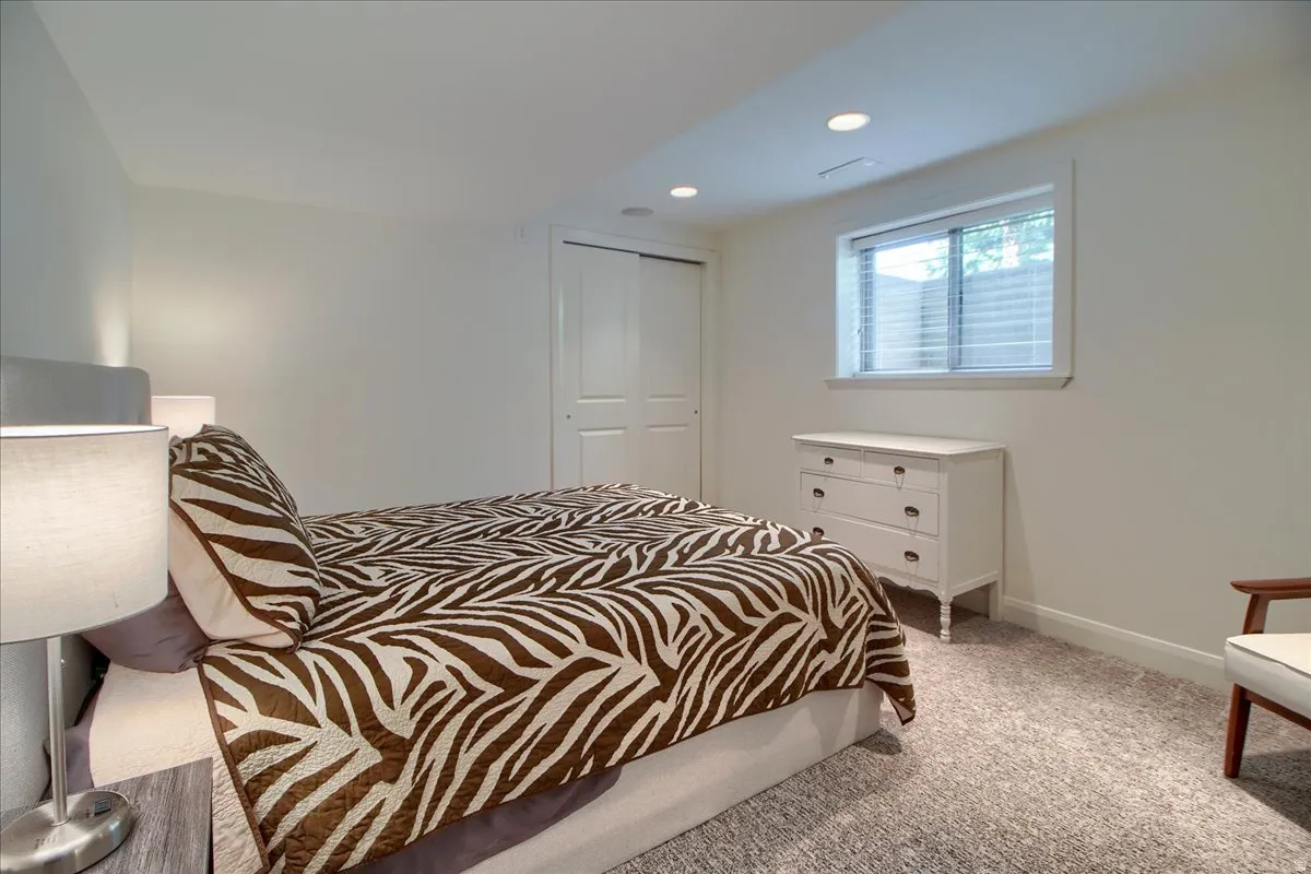 Bedroom with light carpet, a closet, and recessed lighting