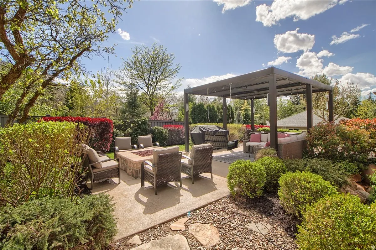 Fenced backyard featuring an outdoor living space with a fire pit, a wooden deck, a pergola, and a patio