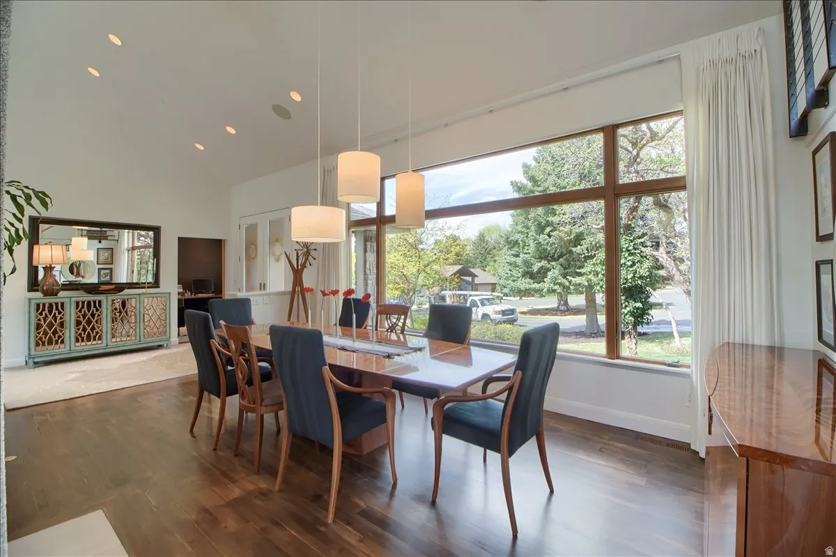 Dining space with dark wood-style flooring, recessed lighting, and lofted ceiling