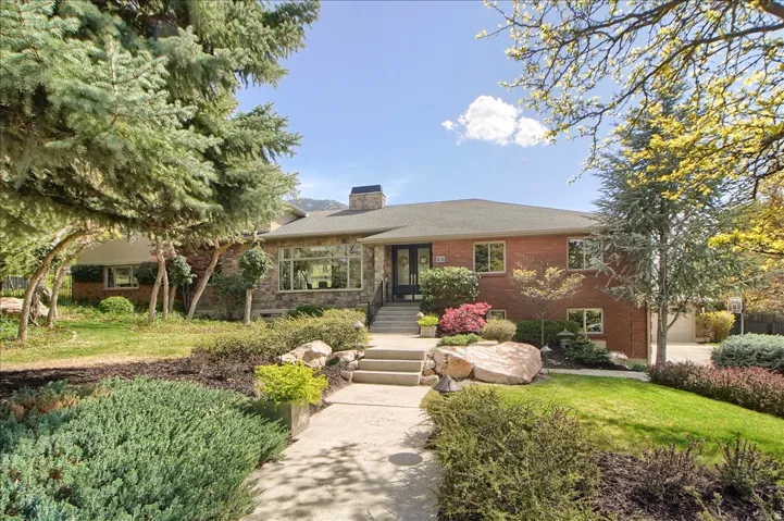 View of front of home featuring a chimney, a front lawn, and brick siding