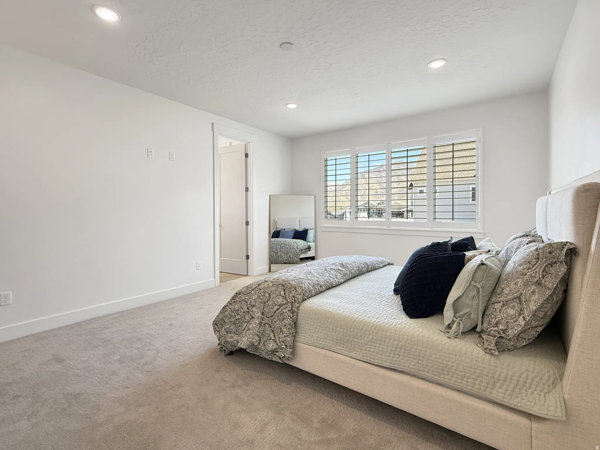 Carpeted bedroom with recessed lighting and a textured ceiling