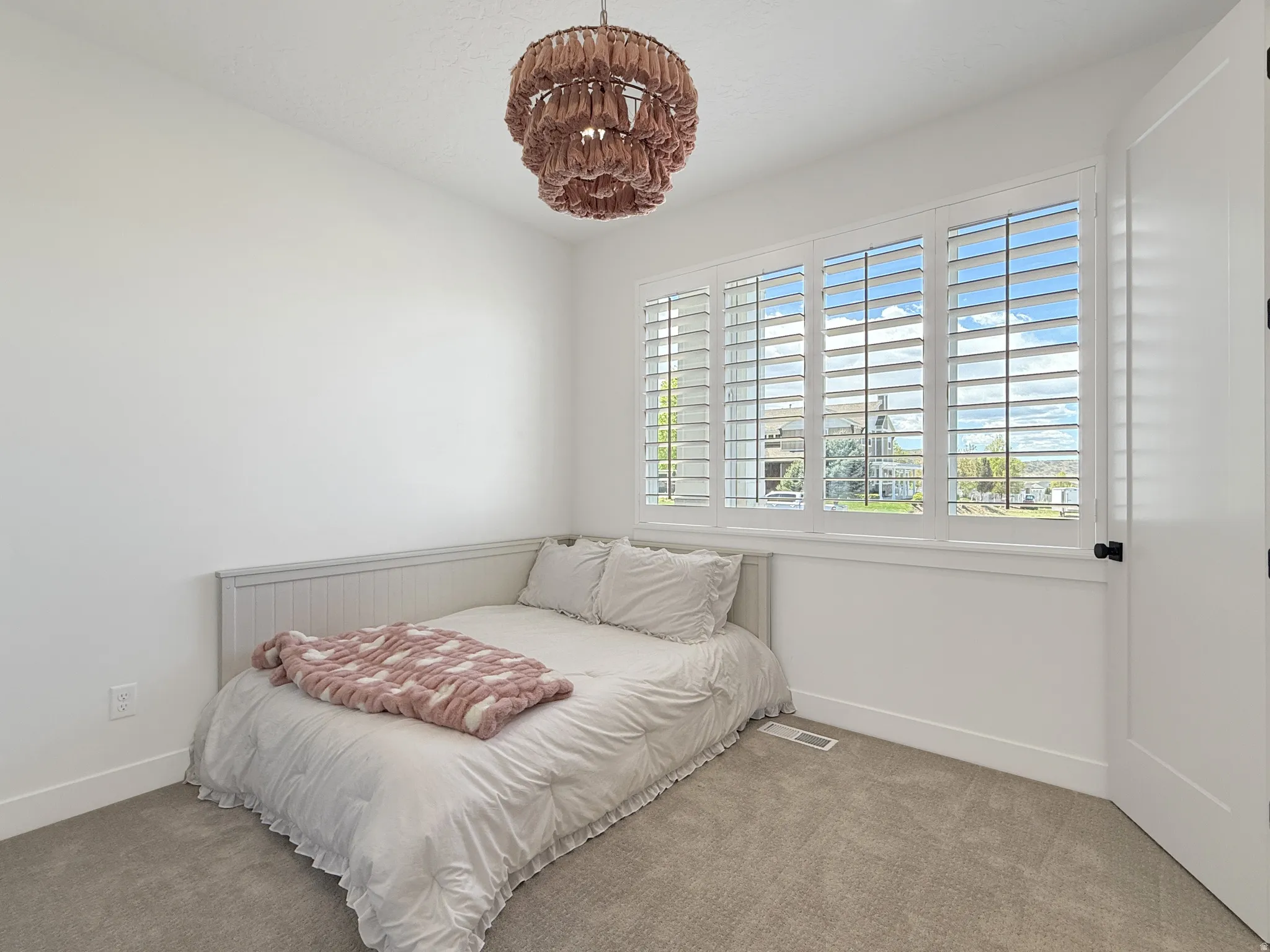Carpeted bedroom featuring baseboards and suspended lighting