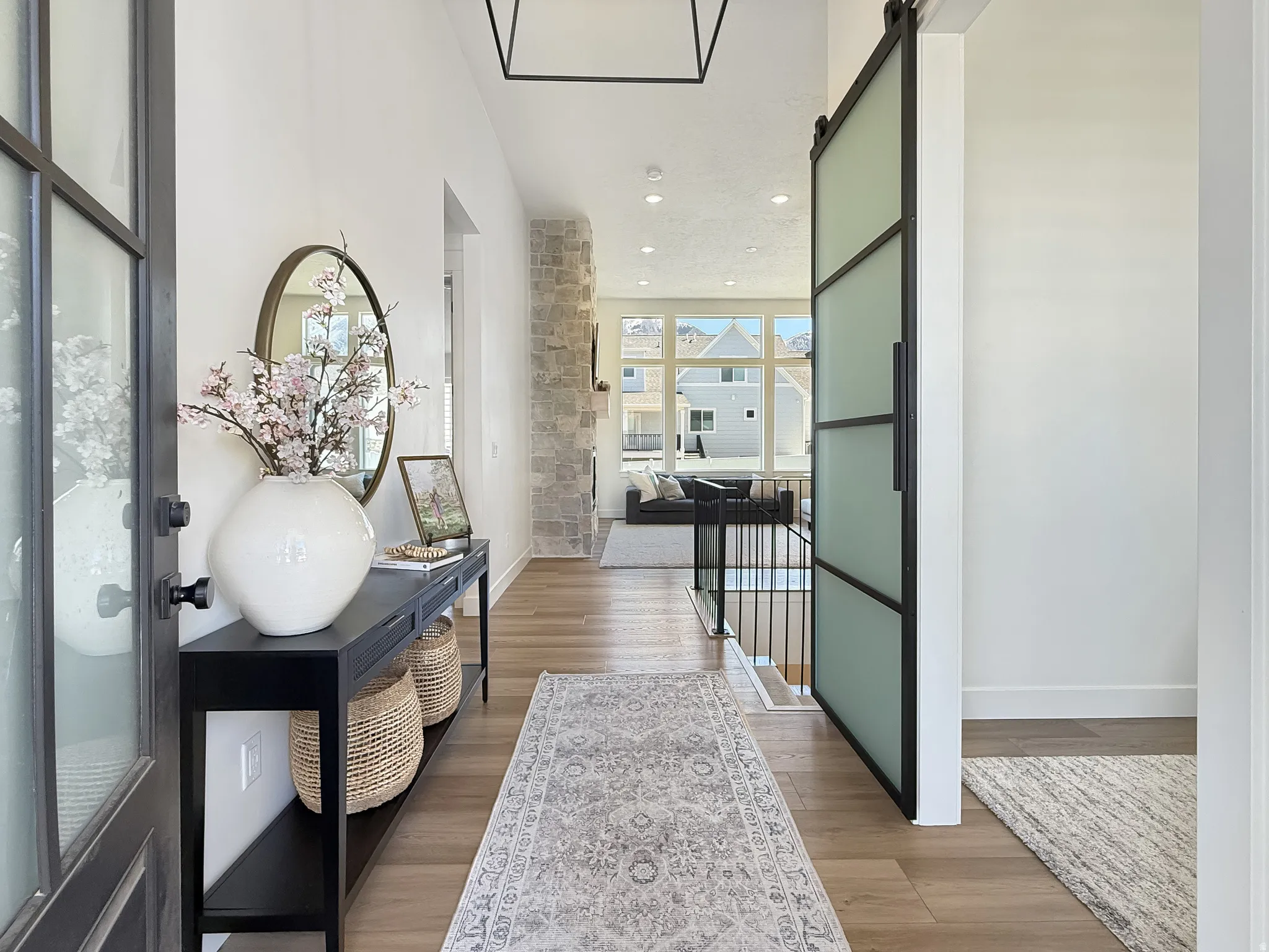Corridor featuring light wood-style floors, a barn door, and recessed lighting