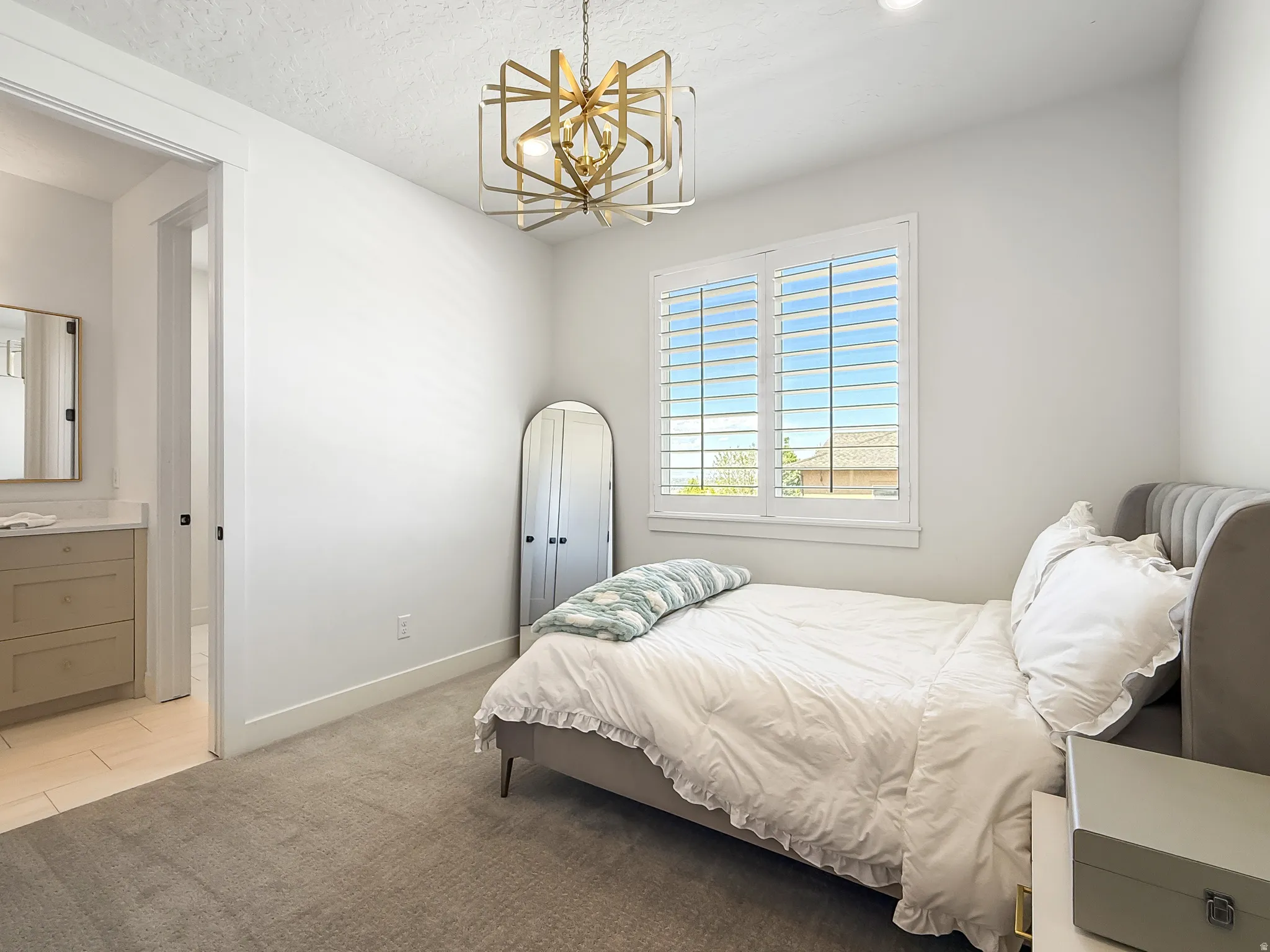 Bedroom with light carpet, a chandelier, light tile patterned flooring, and a textured ceiling