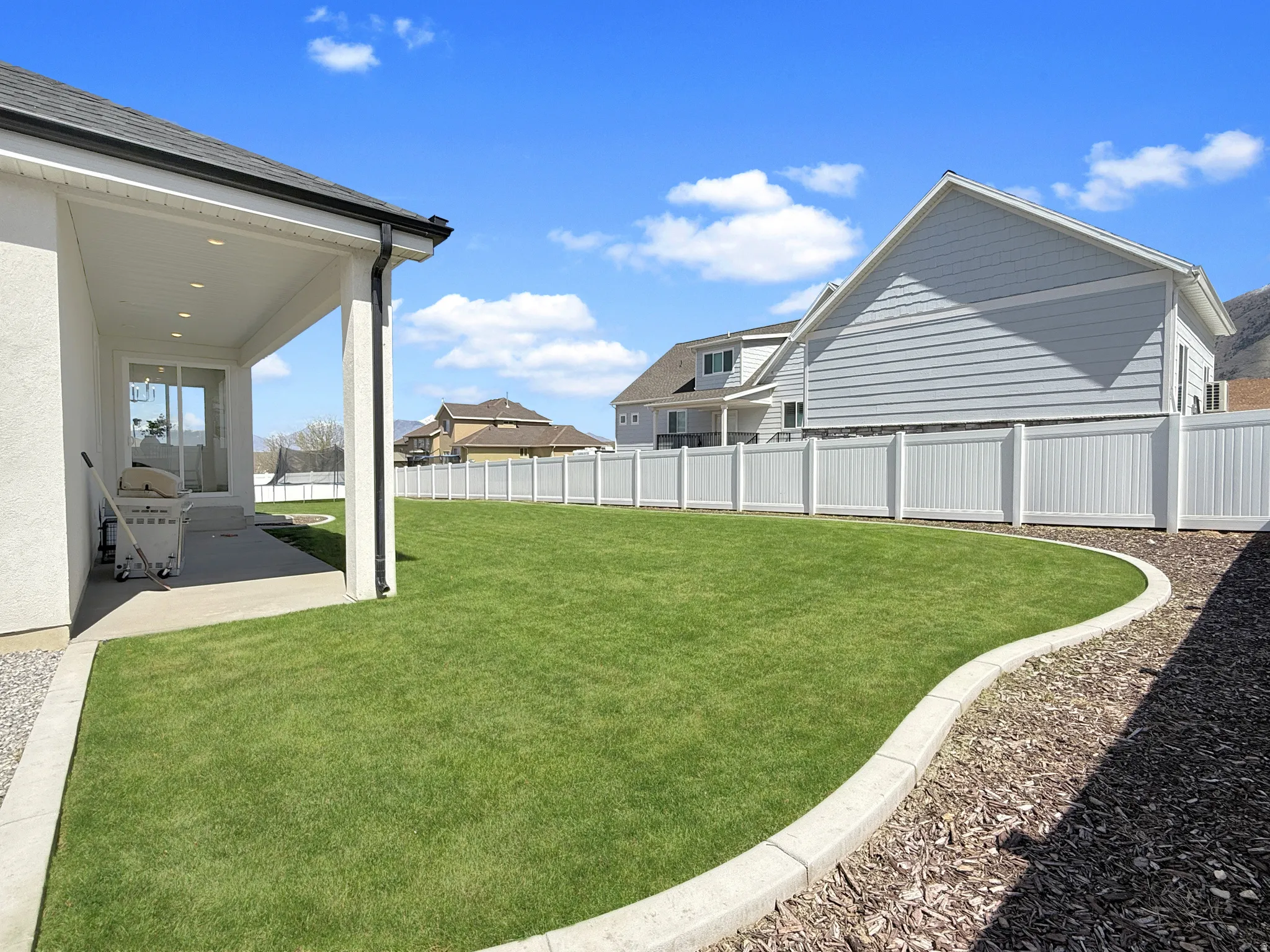 Fenced backyard with a patio area and a residential view
