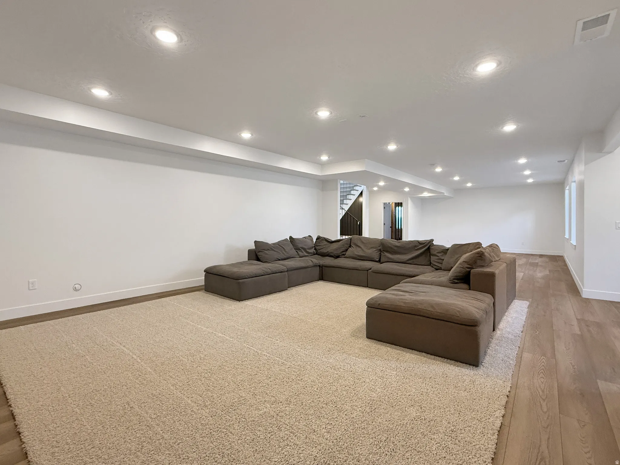 Living area featuring light wood finished floors and recessed lighting