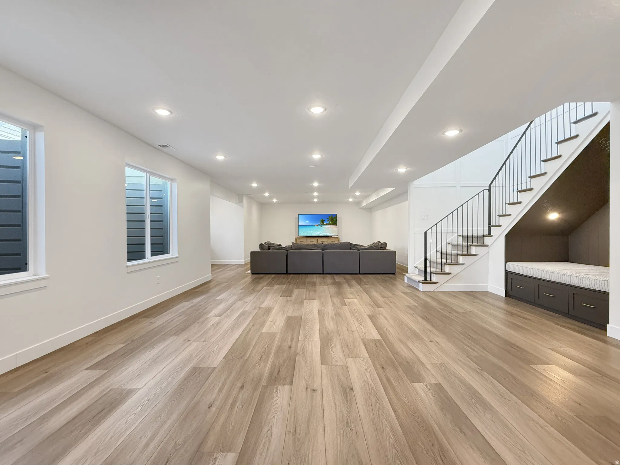 Living area with light wood-type flooring and recessed lighting