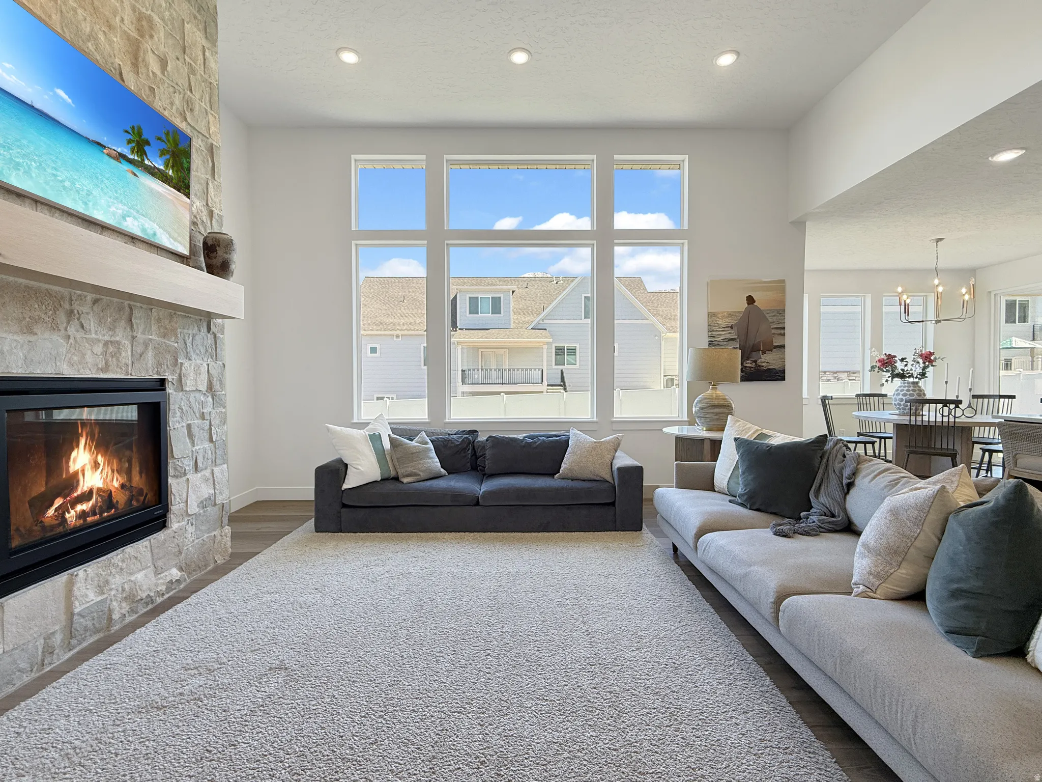 Living area featuring wood finished floors, a fireplace, a textured ceiling, and hanging lights