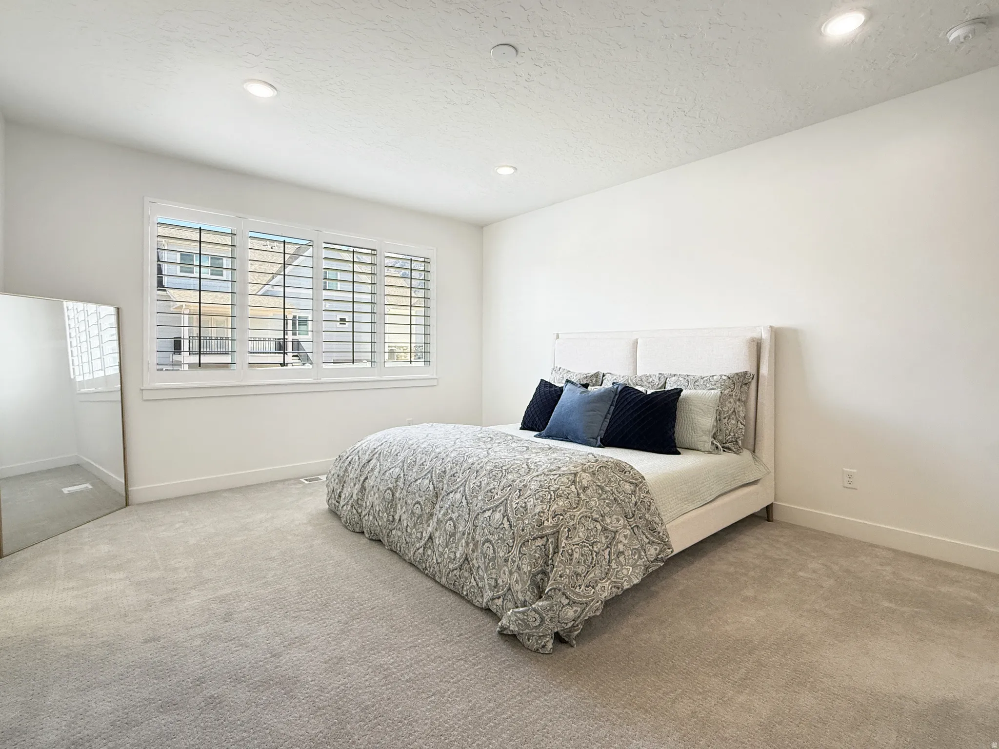 Bedroom with carpet floors, recessed lighting, and a textured ceiling