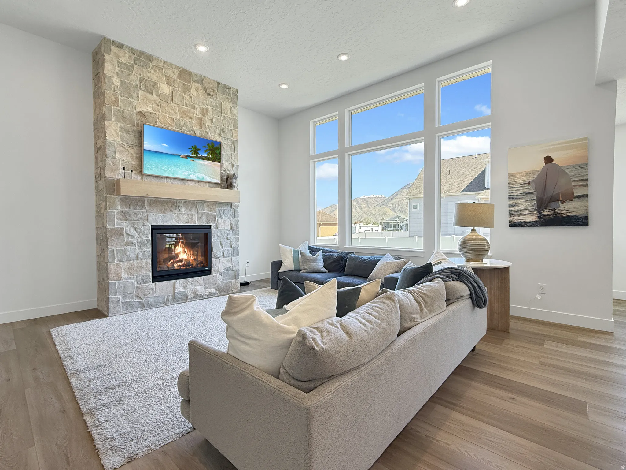 Living room featuring a fireplace, light wood-style flooring, recessed lighting, and a textured ceiling