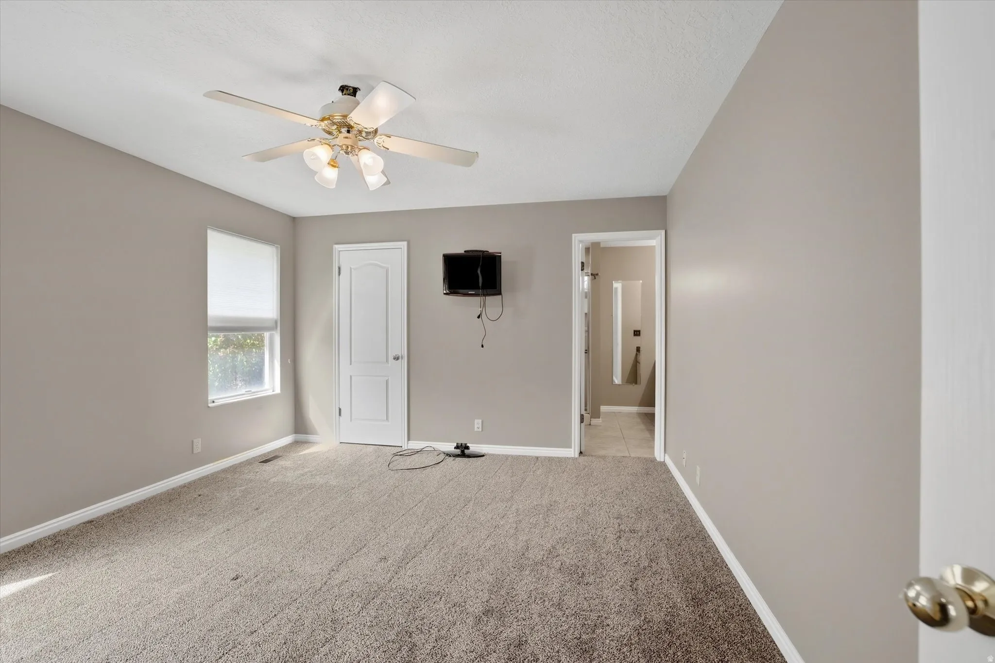 Primary bedroom with ceiling fan and private bathroom