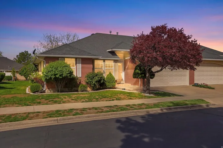 View of front of house featuring driveway, a garage, brick , and a yard