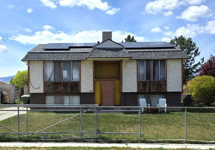 FRONT OF HOME WITH SOLAR PANELS AND FULLY FENCED YARD