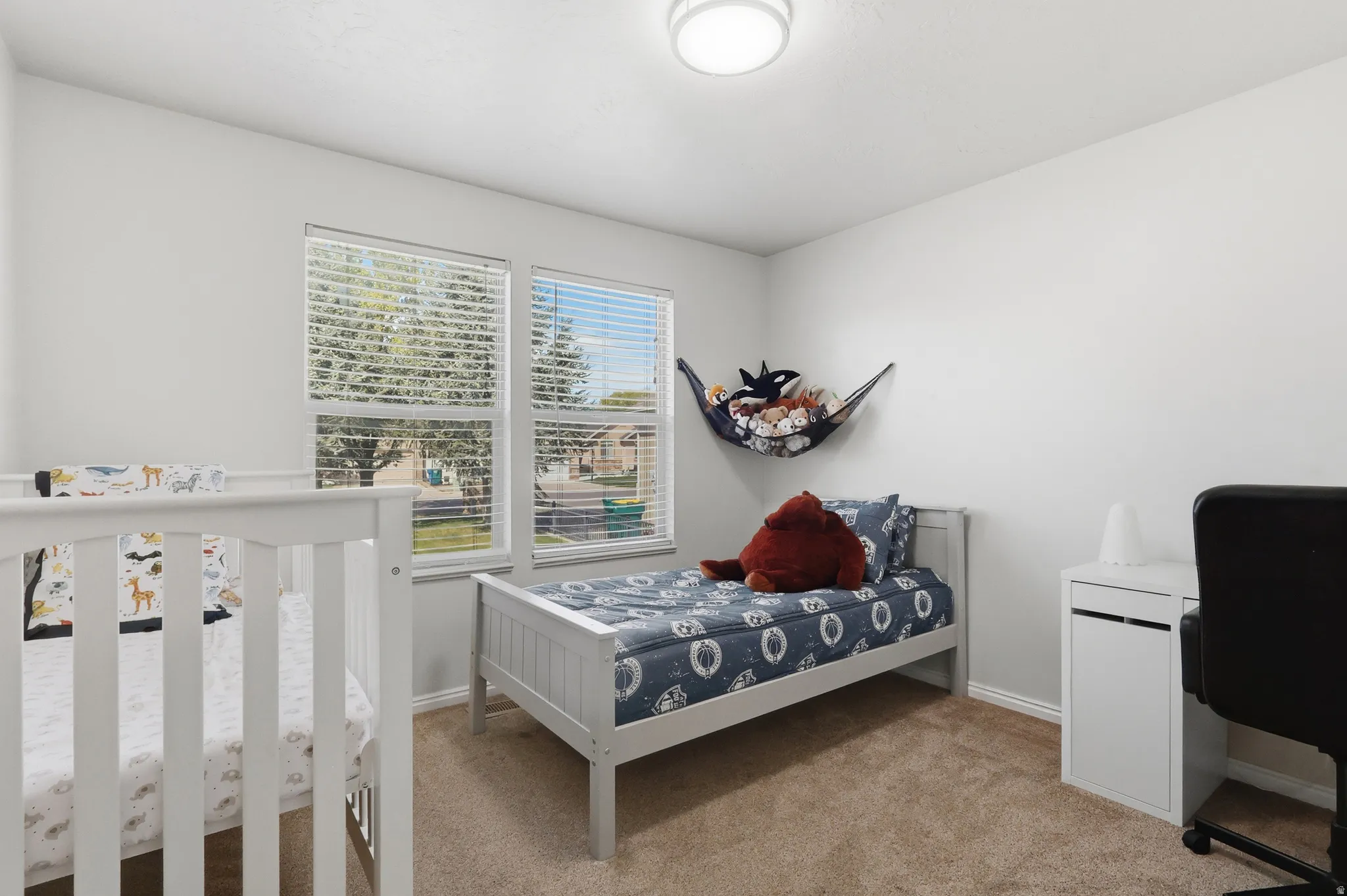 Bedroom #2 on the main level featuring large windows and neutral colors