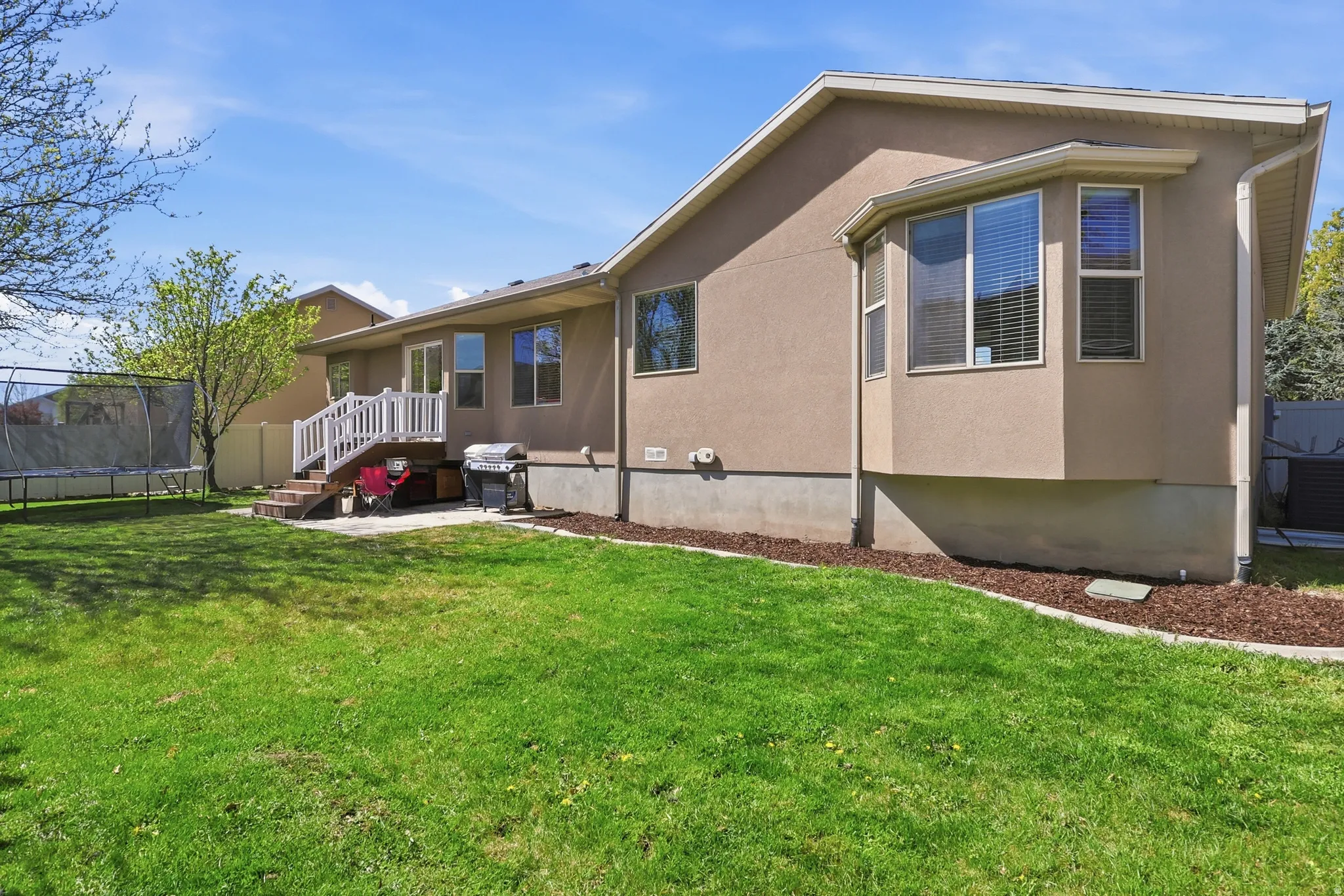 Back of house featuring an east exposure perfect for enjoying afternoon shade and evening BBQs & fun on the trampoline.
