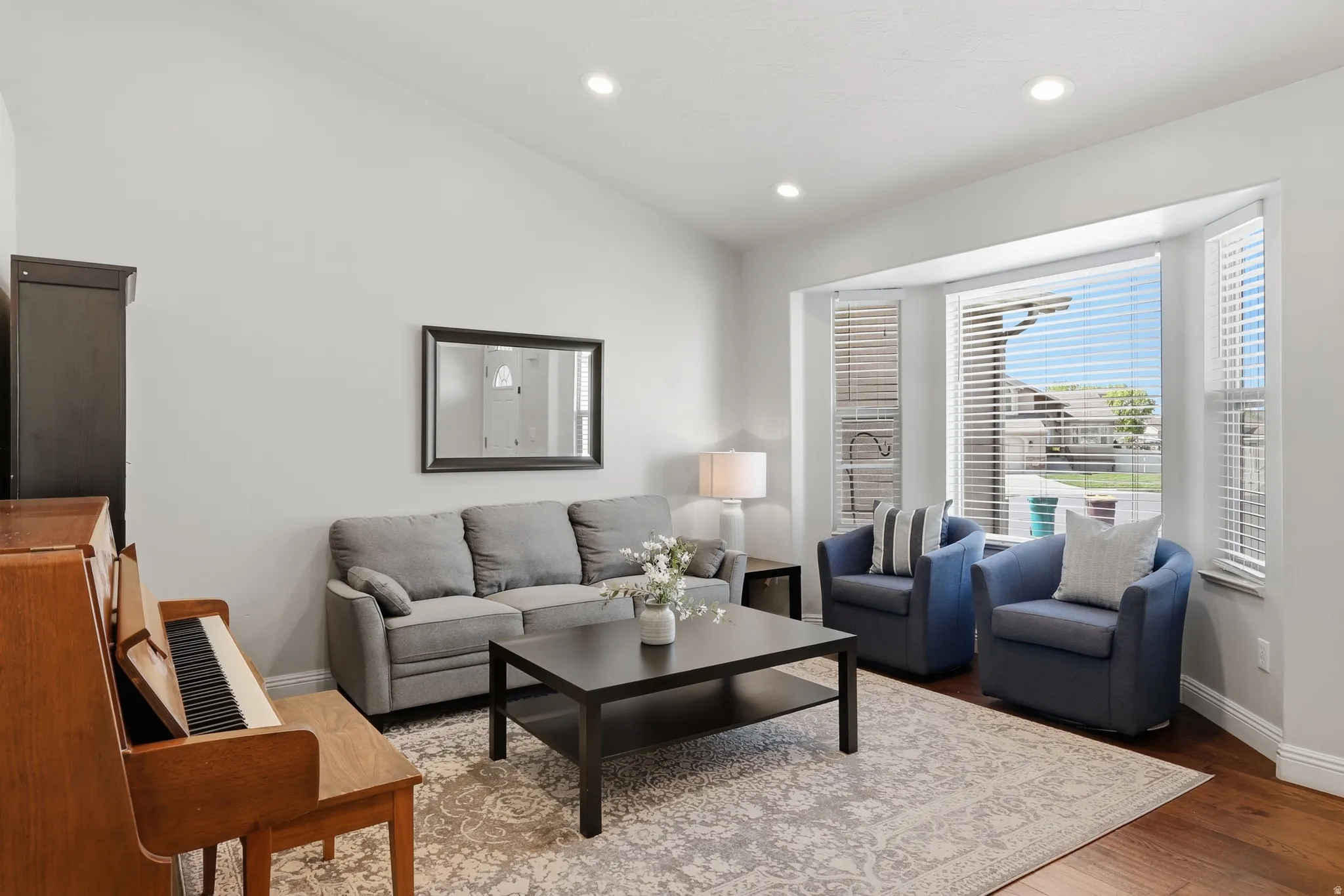 Living area with wood finished floors, recessed lighting, and lofted ceiling