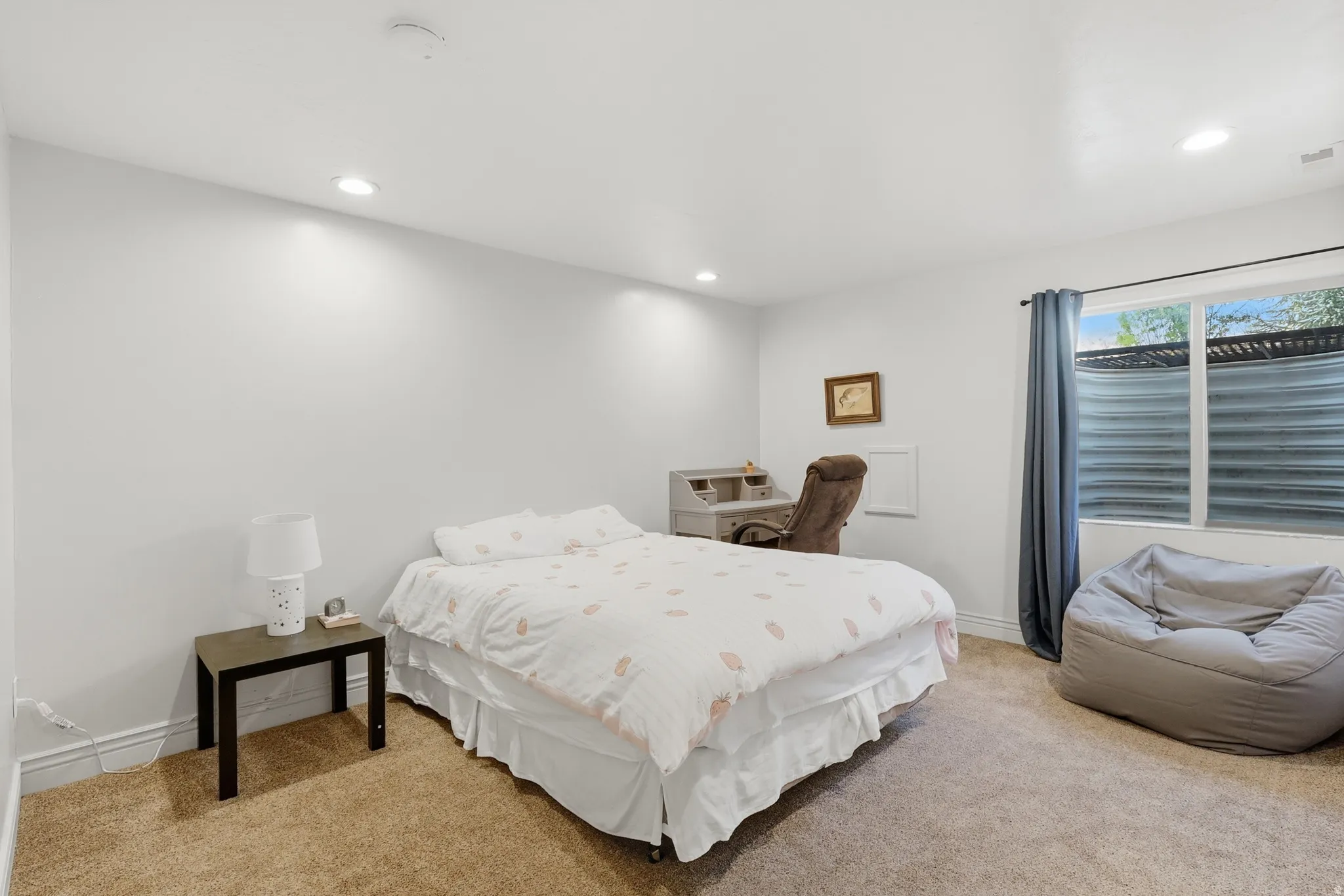 Bedroom #5 featuring large window, light carpet and recessed lighting