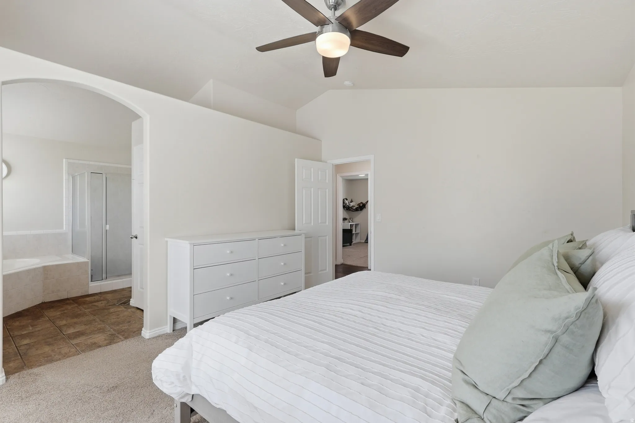 Master suite with arched walkways, a ceiling fan, ensuite bathroom,  vaulted ceiling & fan