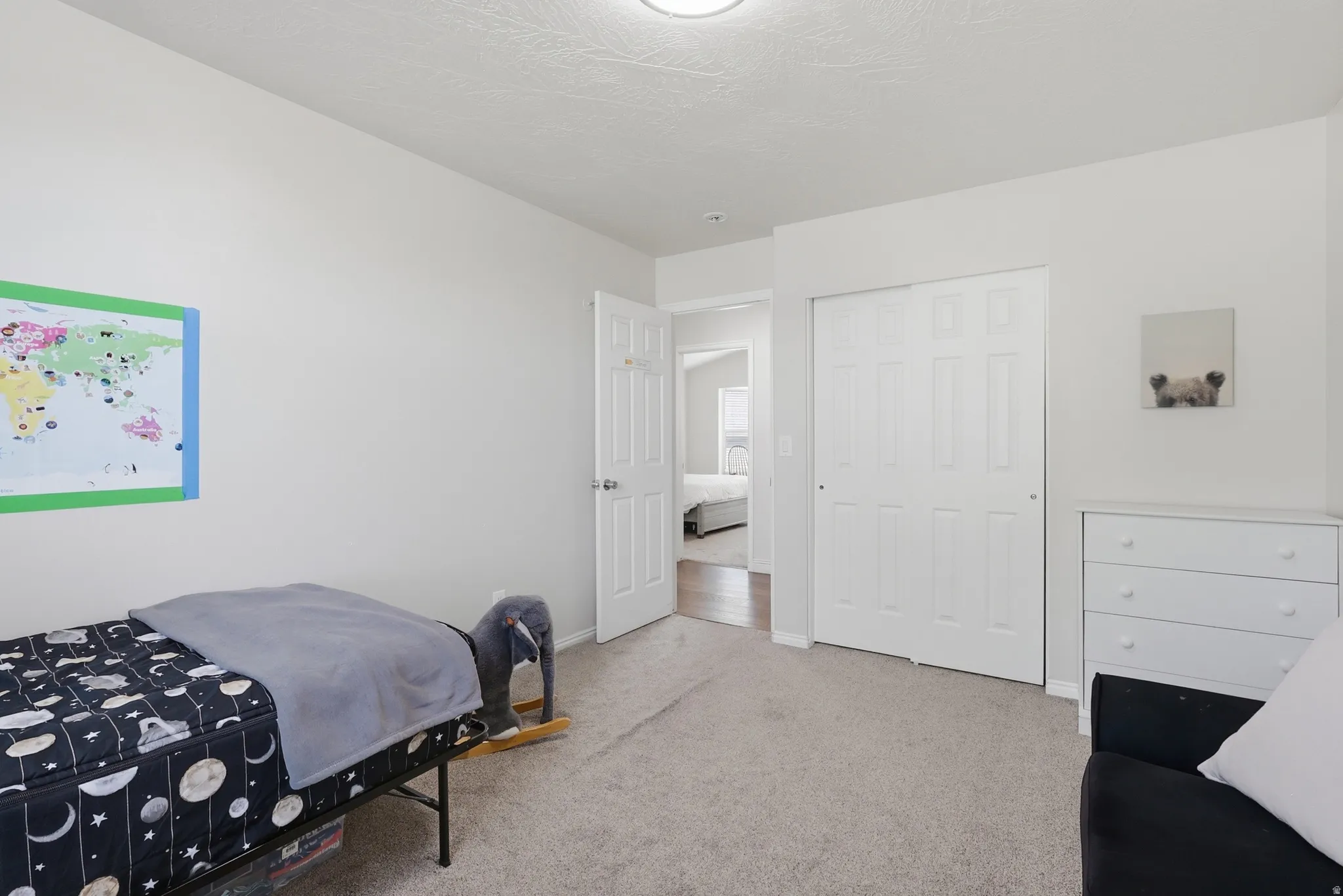 Bedroom with light colored carpet and a closet