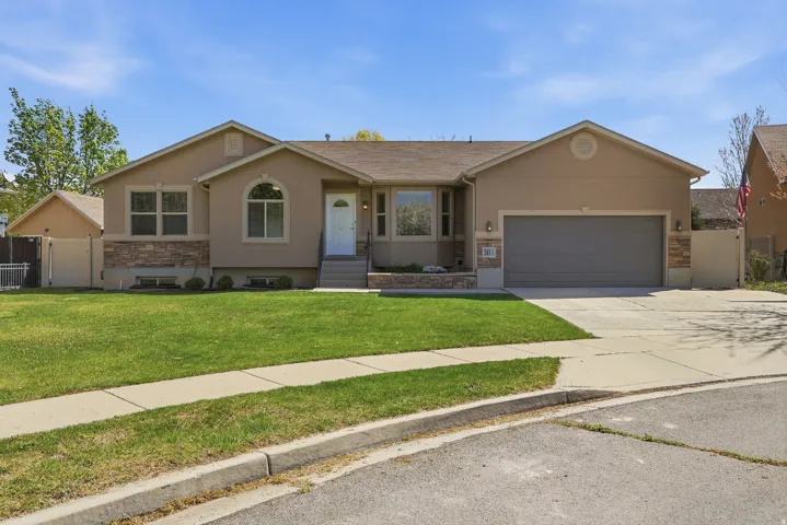 Cut-de-sac home with great curb-appeal featuring stone & stucco, concrete driveway, an attached garage, and a gate to a private fenced back yard.