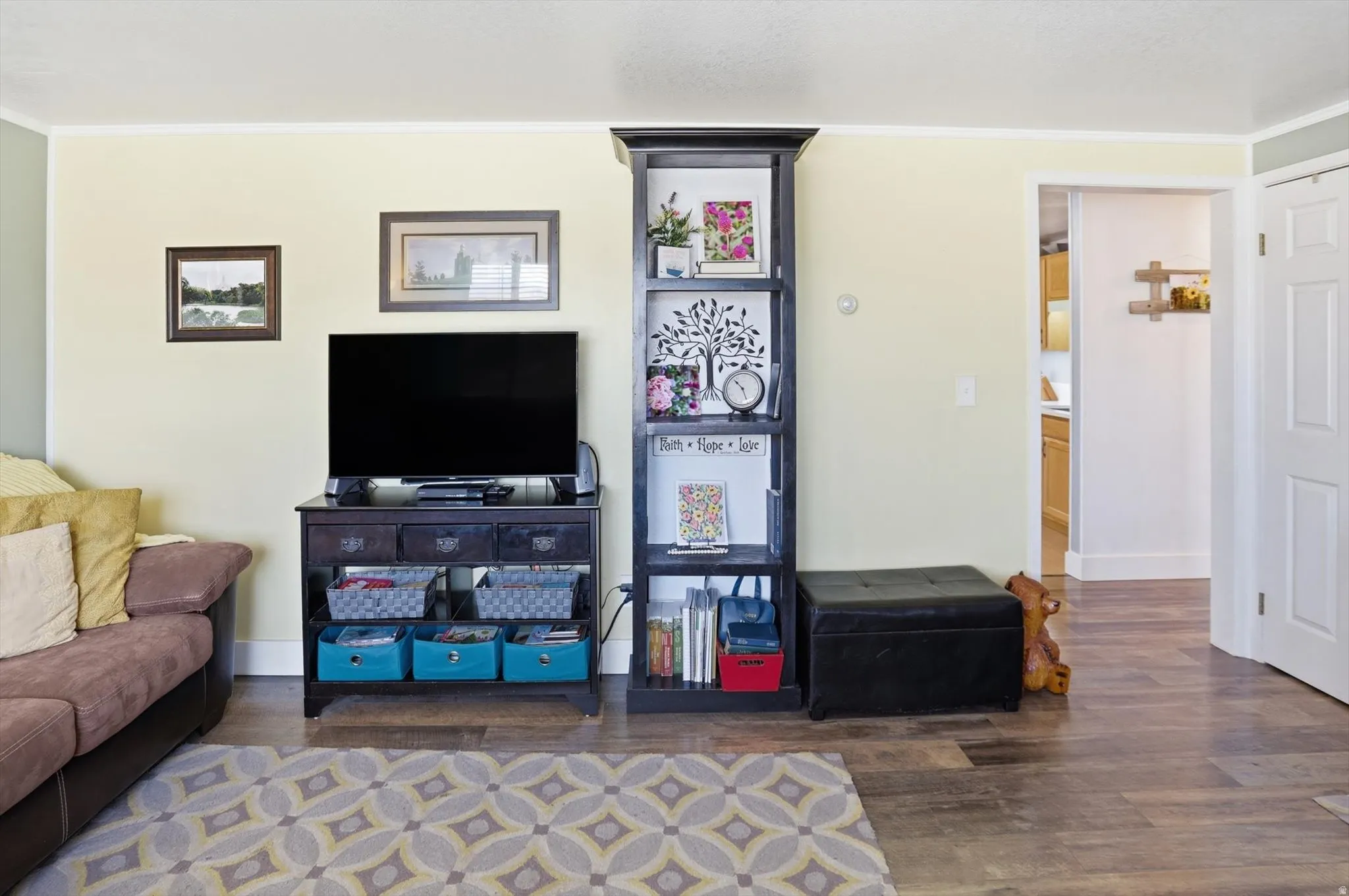 Living area featuring wood finished floors and crown molding