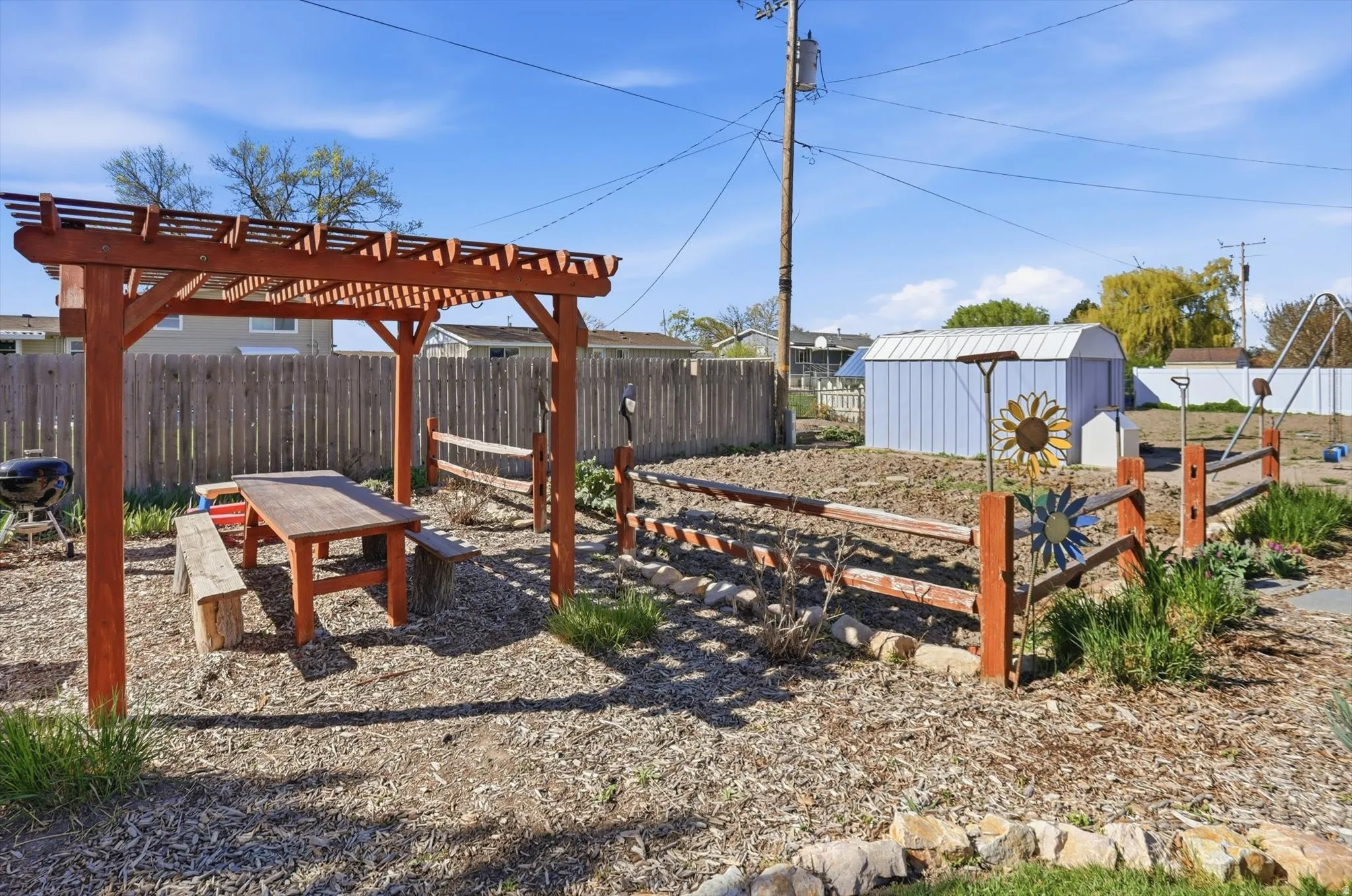 Fenced backyard with a pergola and a shed