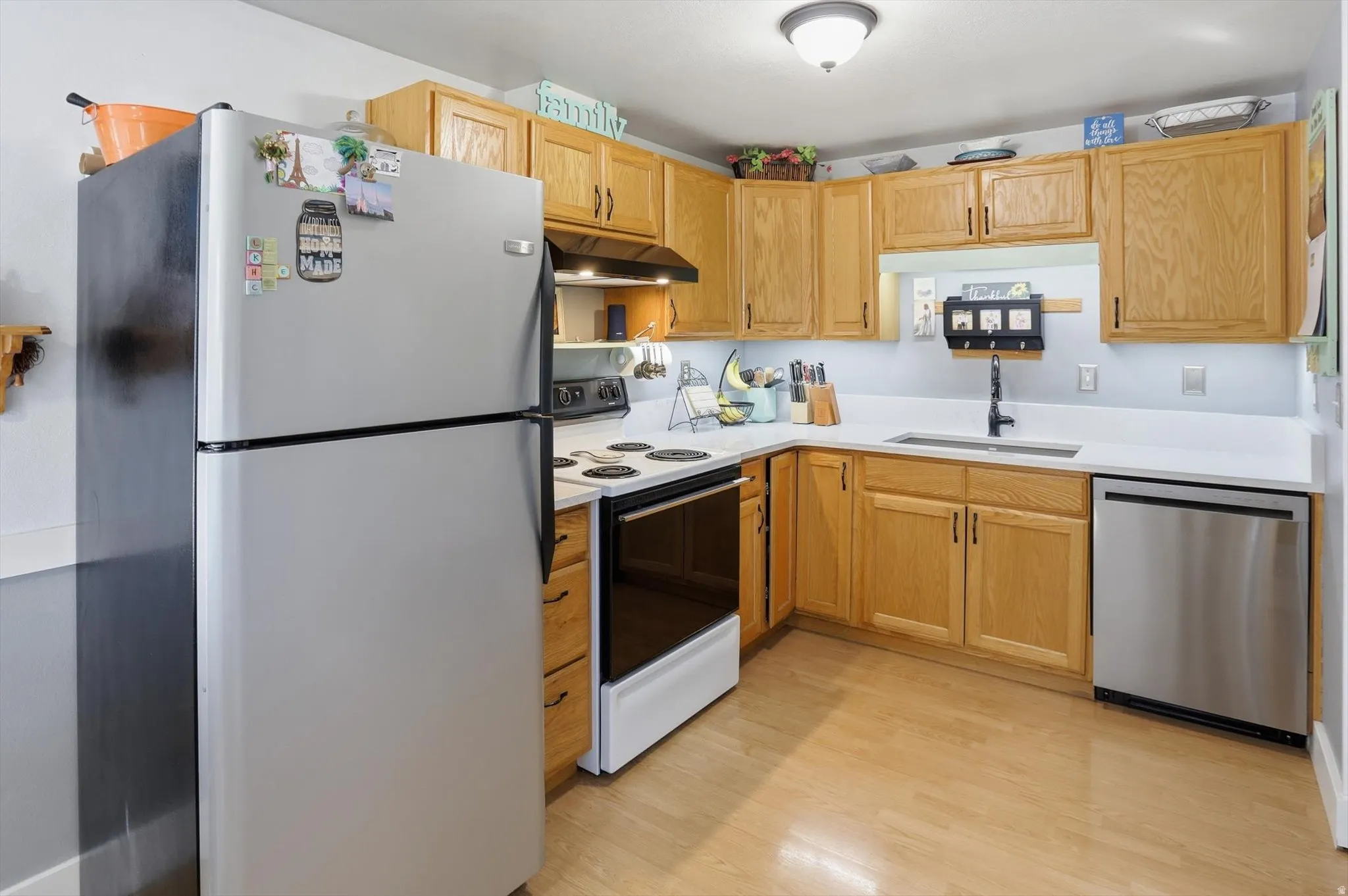 Kitchen with stainless steel appliances, light wood finish cabinetry, and light wood-style floors