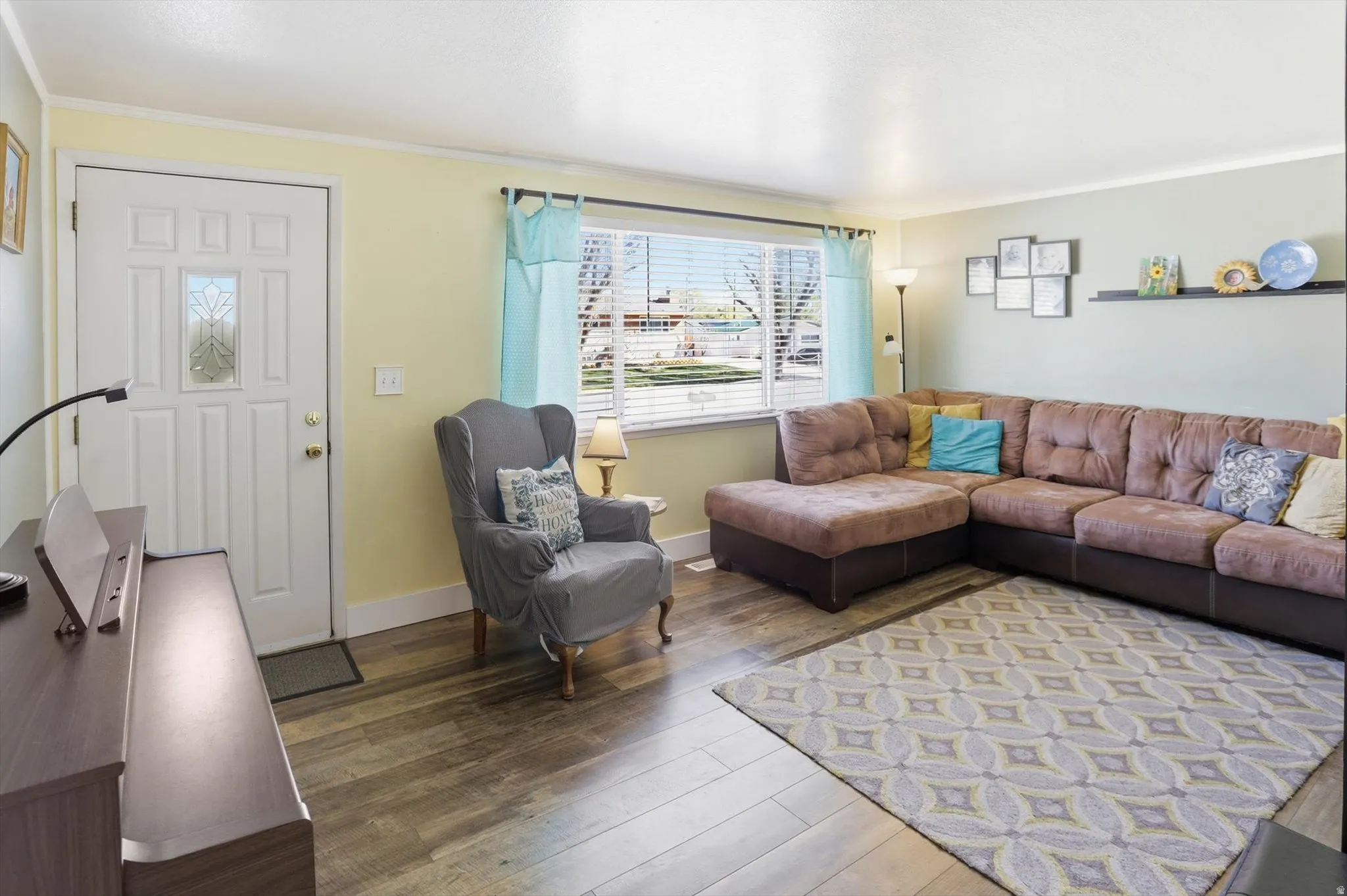 Living area with hardwood / wood-style flooring and crown molding