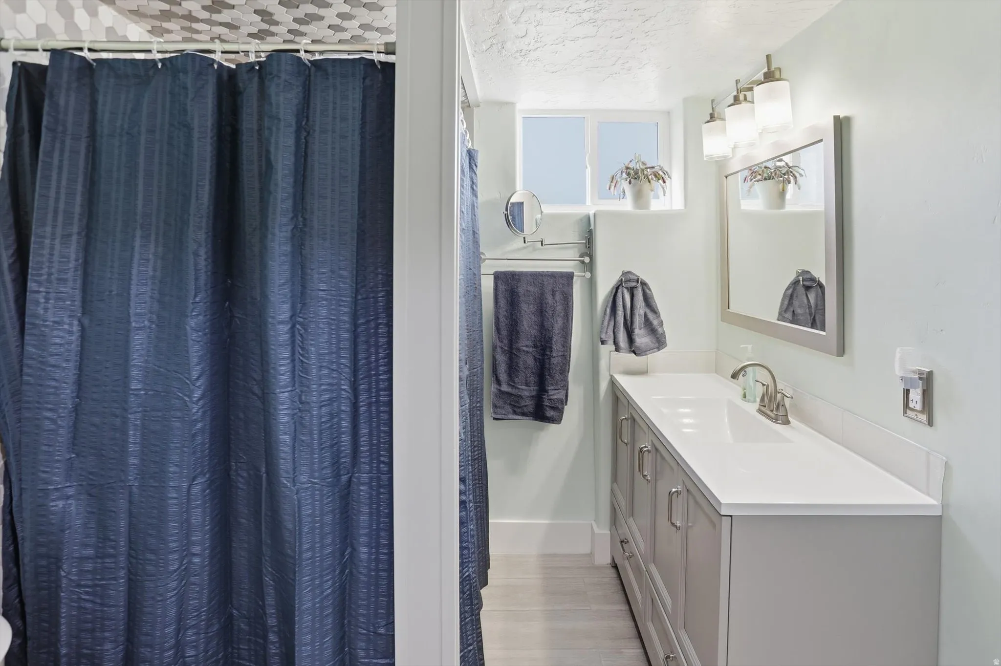 Full bath featuring vanity, a textured ceiling, and a shower with curtain