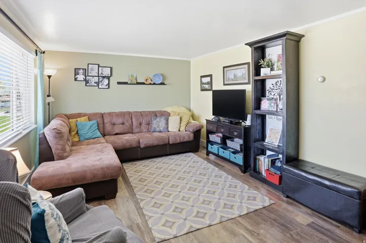 Living area featuring wood finished floors and ornamental molding