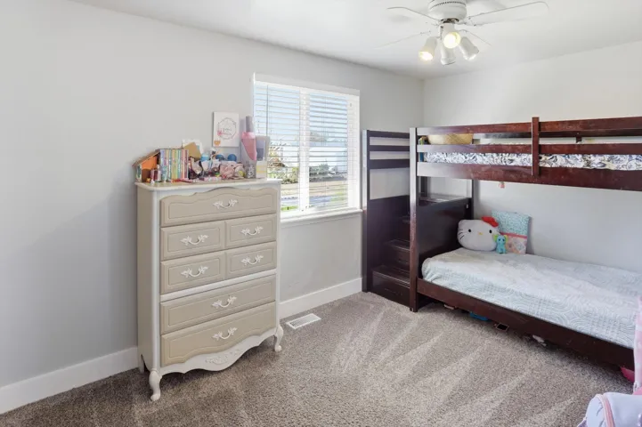 Bedroom featuring light colored carpet and a ceiling fan