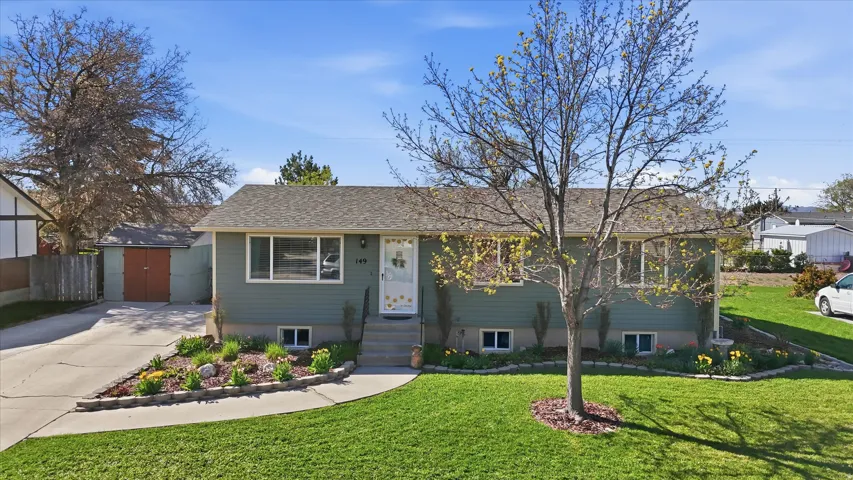 View of front of house featuring a front yard, an outbuilding, and driveway