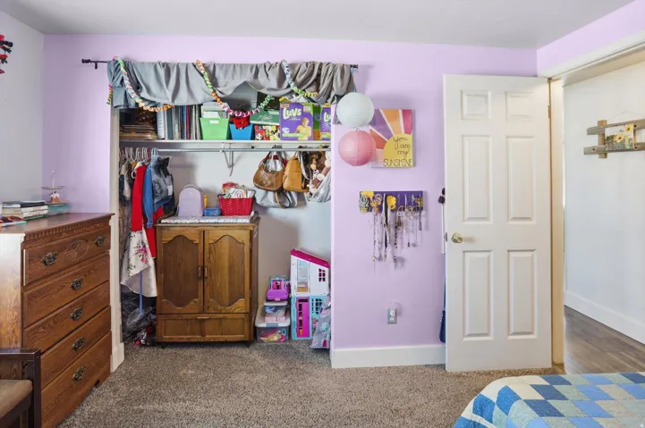 Bedroom featuring dark colored carpet and a closet