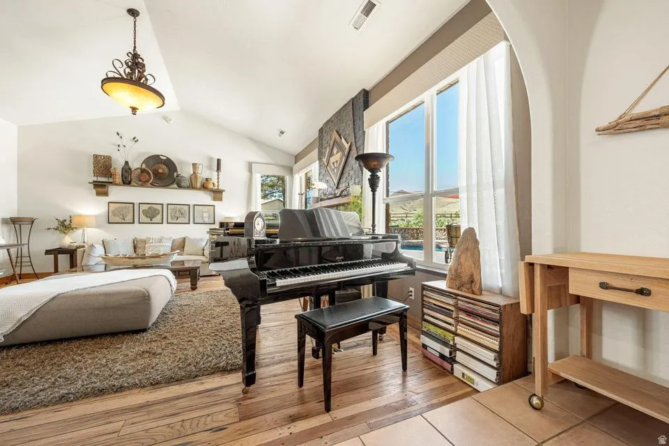 Living area with light wood-type flooring and vaulted ceiling