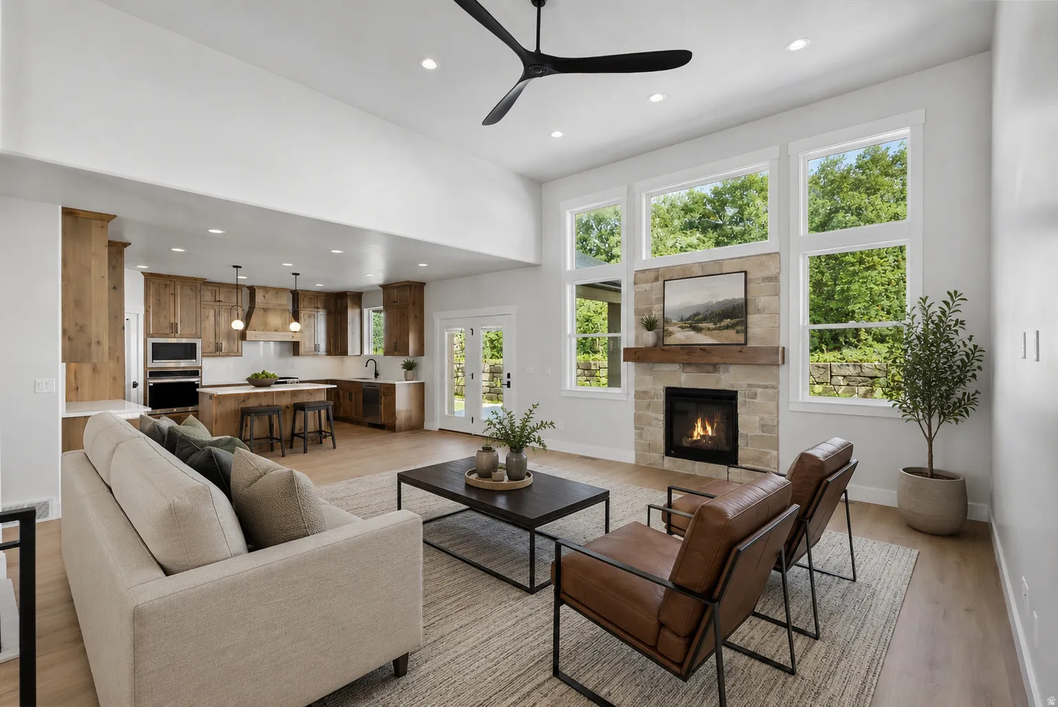 Spacious living area featuring a stacked stone fireplace with a wood-beam mantle, a wall of windows, recessed lighting, and wood-finish flooring