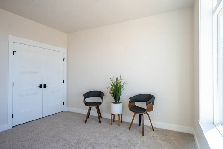 Light-colored walls with white trim, double panel doors with black hardware, and carpeted flooring