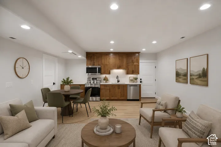 Open-concept living area featuring light wood-finish flooring, recessed lighting, and white walls
