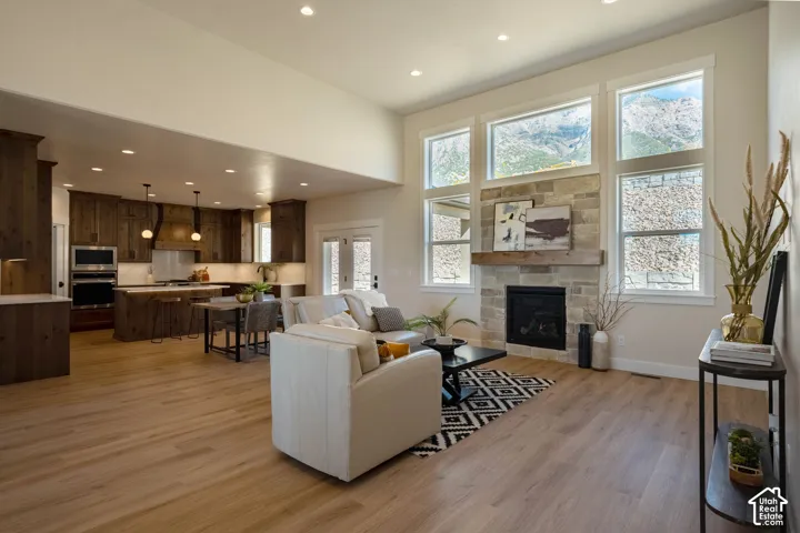 Wood-finish flooring throughout, vaulted ceilings, and a stone-faced fireplace with a wood mantel