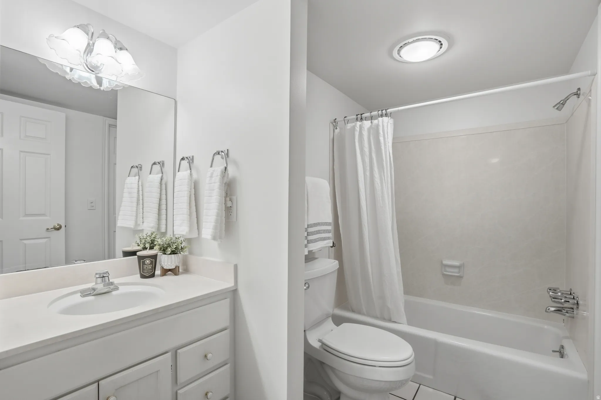 Bathroom featuring vanity, shower / tub combo, and tile patterned flooring