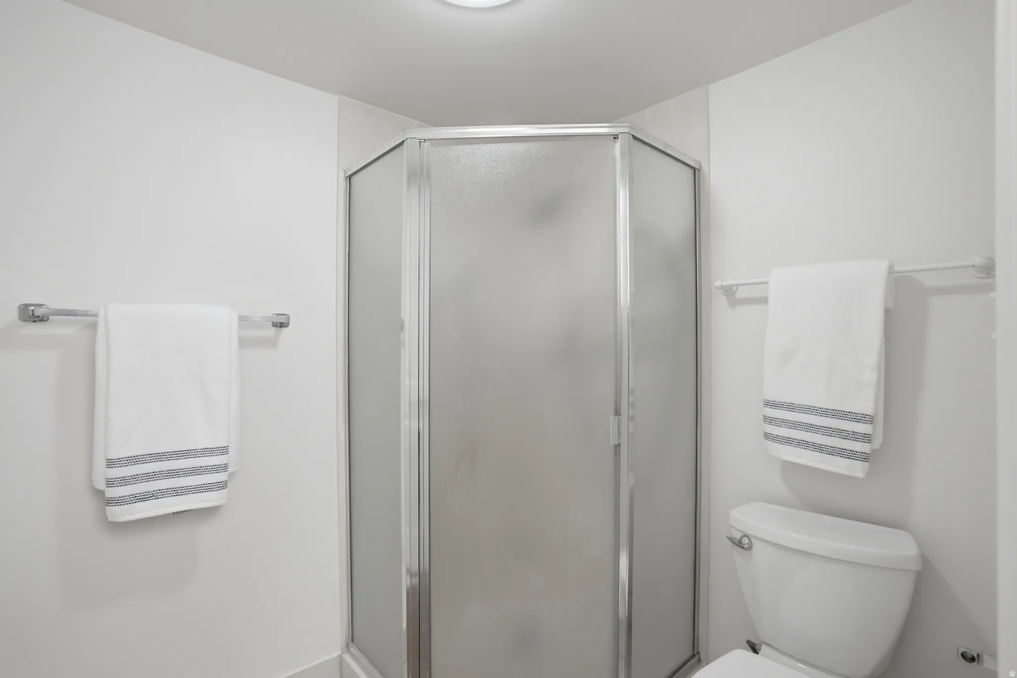 Bathroom featuring a shower stall and toilet
