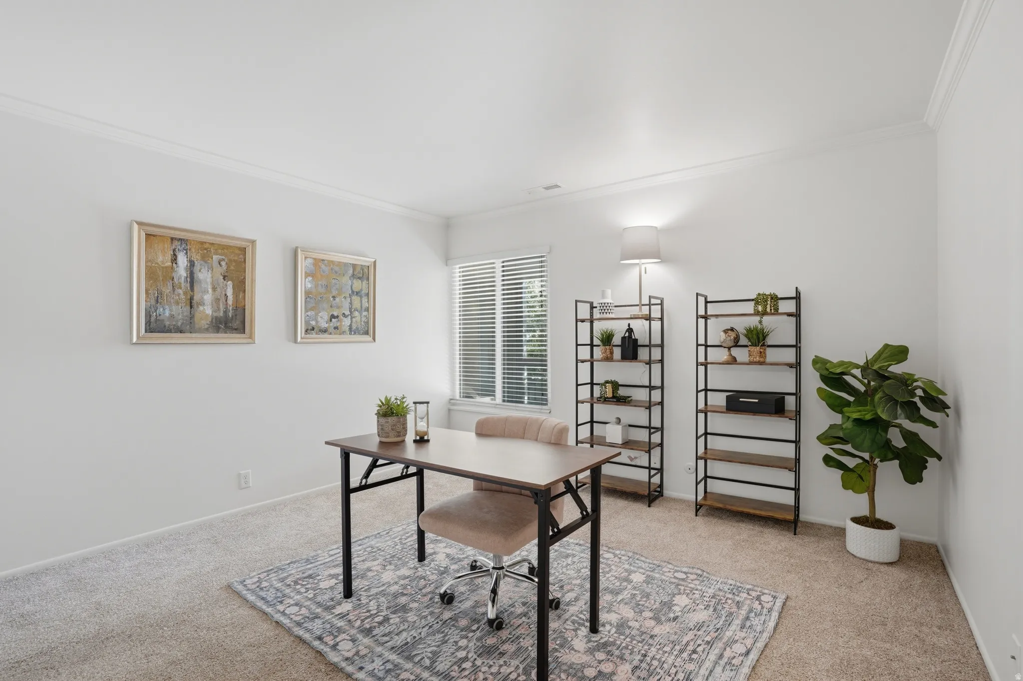 Office area with crown molding and light colored carpet