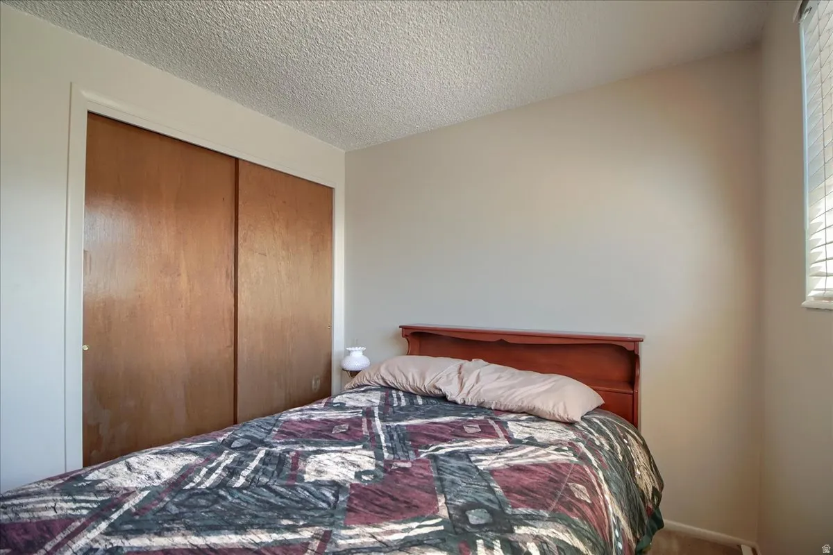 Bedroom featuring a textured ceiling and a closet