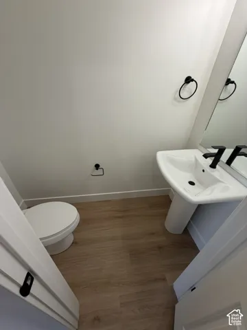 Bathroom with wood finished floors and baseboards